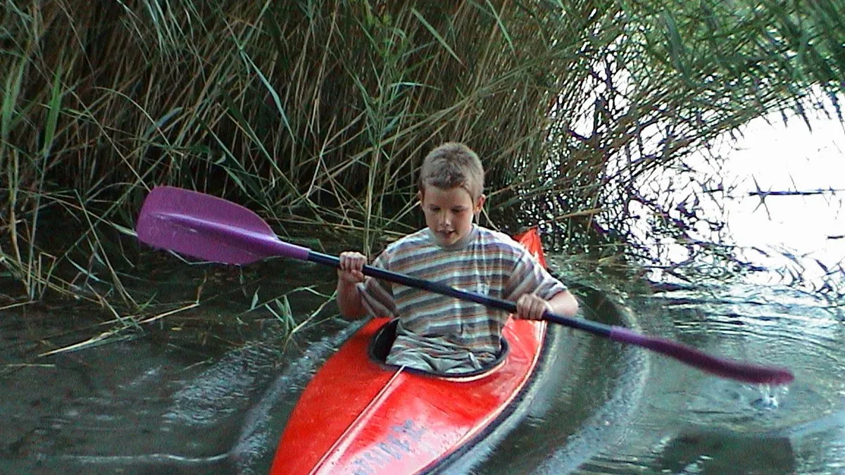 Young Adrian kayaking on the river