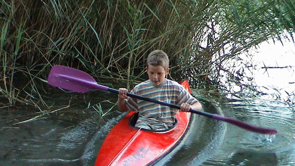 Young Adrian kayaking on the river